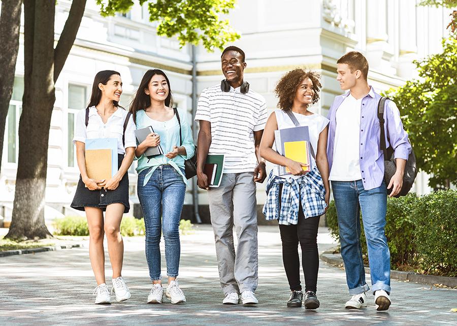 a diverse group of high school students walking on campus